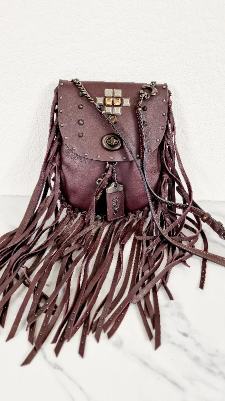 Coach Tabby bags with a classic turnlock closure for a timeless styleCoach 1941 Fringe Saddle Bag with Pyramid Rivets in Oxblood Smooth Leather & Ram Charm - Coach 48617